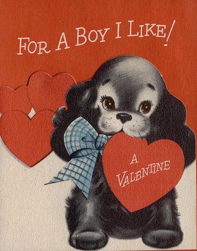 a valentine card with a black dog holding two heart shaped red hearts and the words for a boy i like