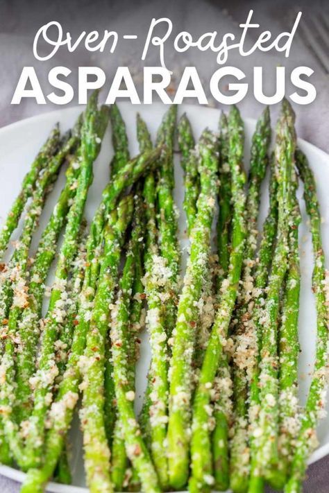 cooked asparagus on a white plate with parmesan sprinkles