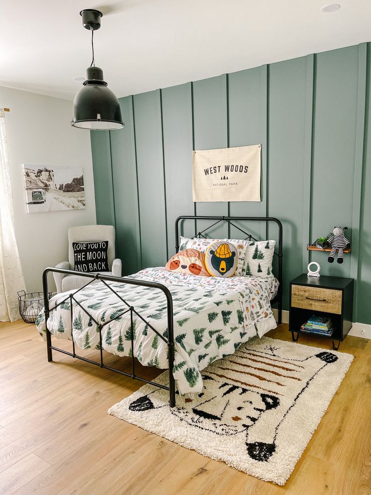 a bed room with a neatly made bed and a rug on the wooden flooring