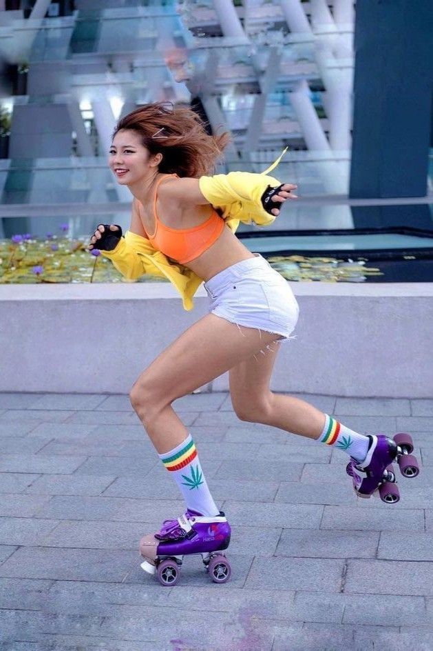 a woman rollerblading down the street in an orange top and white shorts with colorful socks