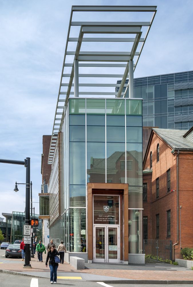 two people walking down the street in front of a building with an awning over it