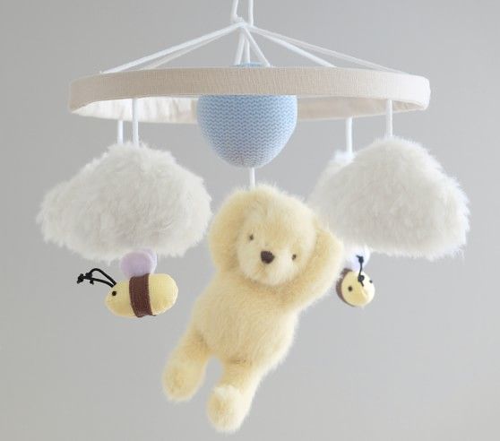 a teddy bear is hanging from a mobile