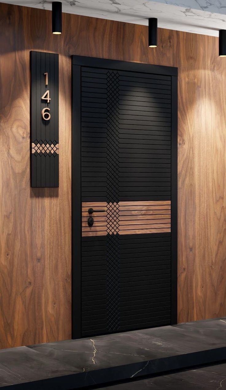 a black and gold door with numbers on the side next to a wooden paneled wall