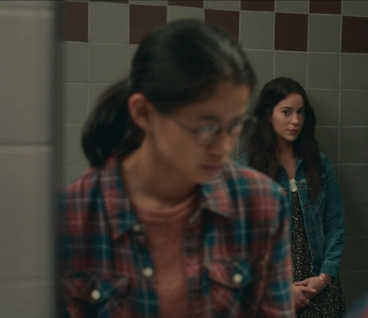 two young women standing in a bathroom next to each other