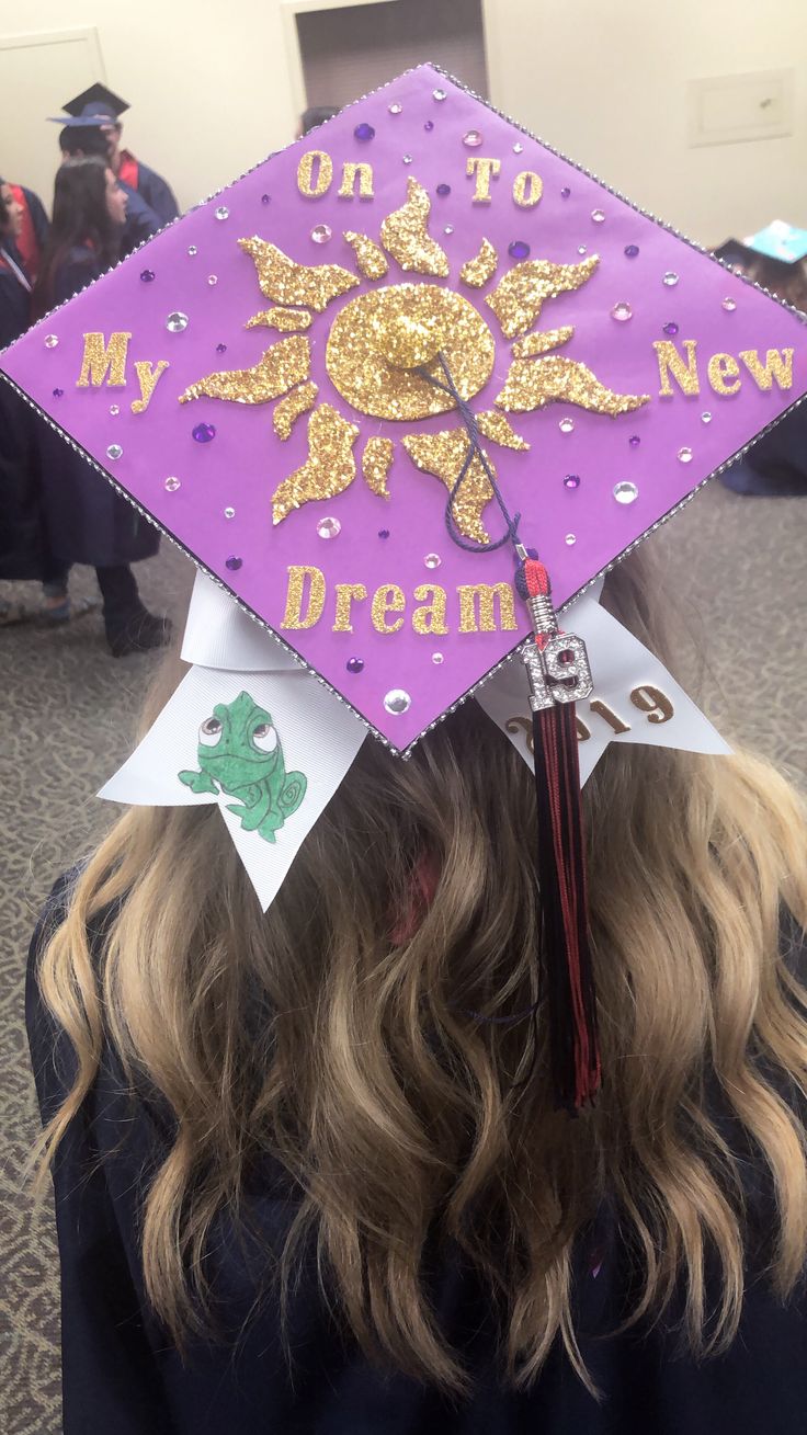 a purple and gold graduation cap with the words on to my new dream written on it