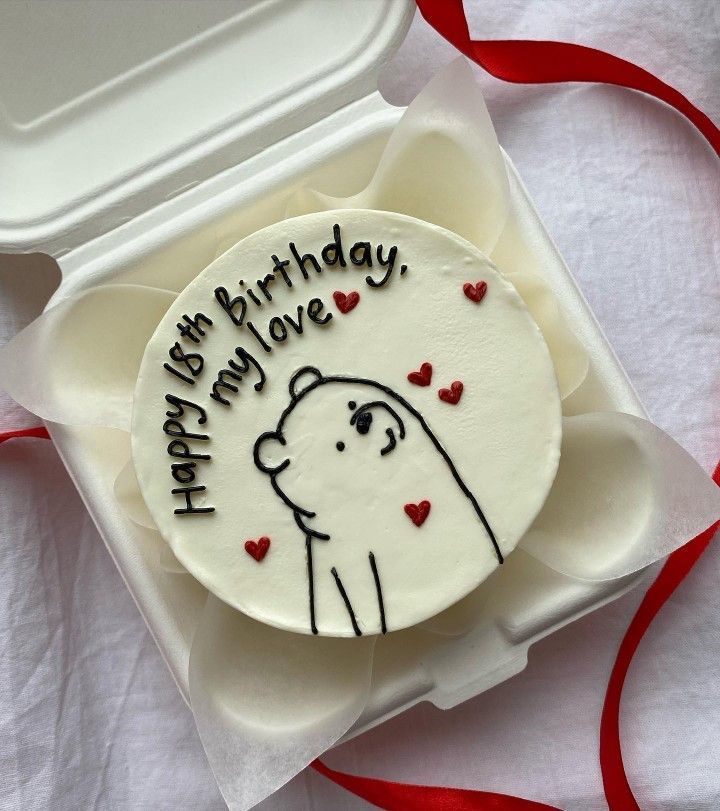 a decorated birthday cake in a box on a table