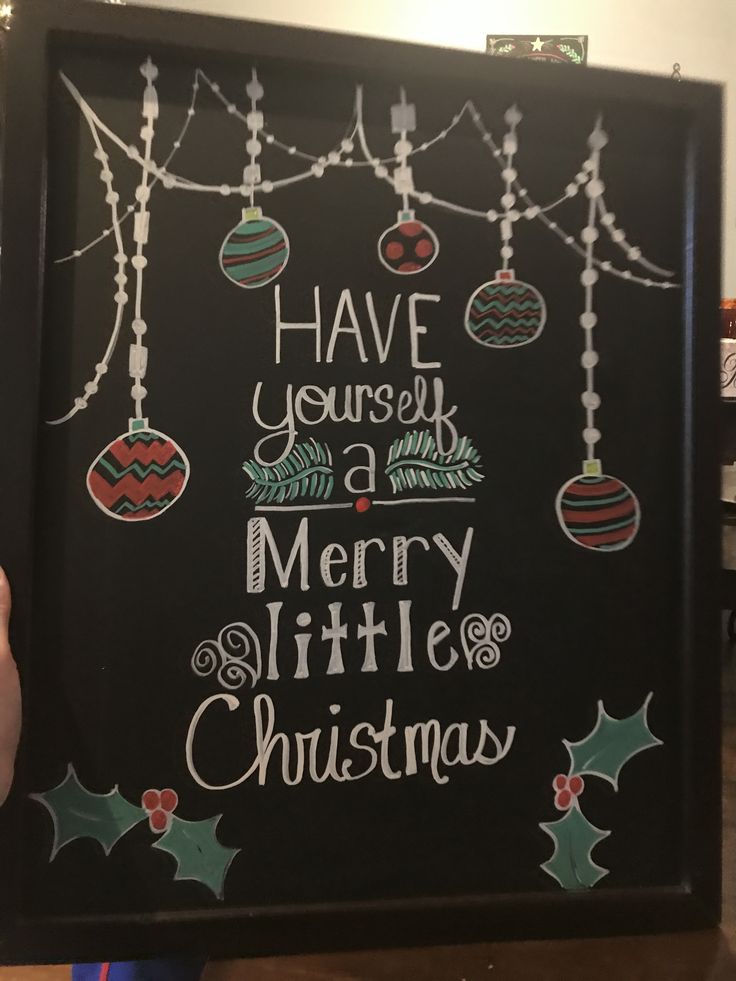 a chalkboard with christmas ornaments hanging from it's sides and the words have yourself merry little christmas written on it