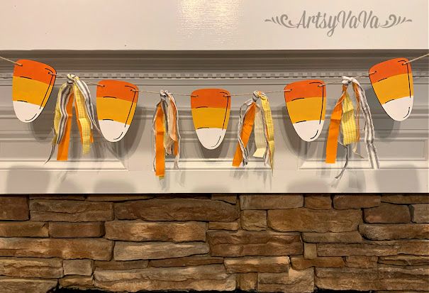 orange and white hats hanging from a line on a brick wall next to a fireplace