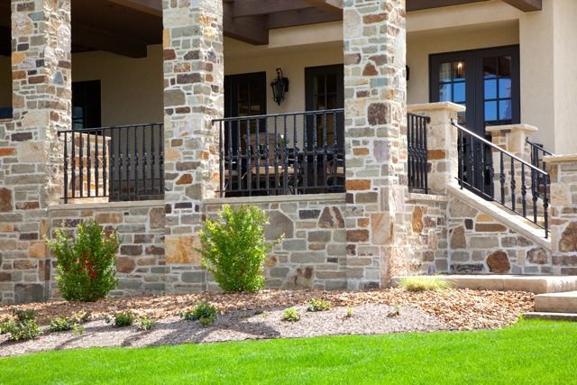 a house with stone pillars and balconies