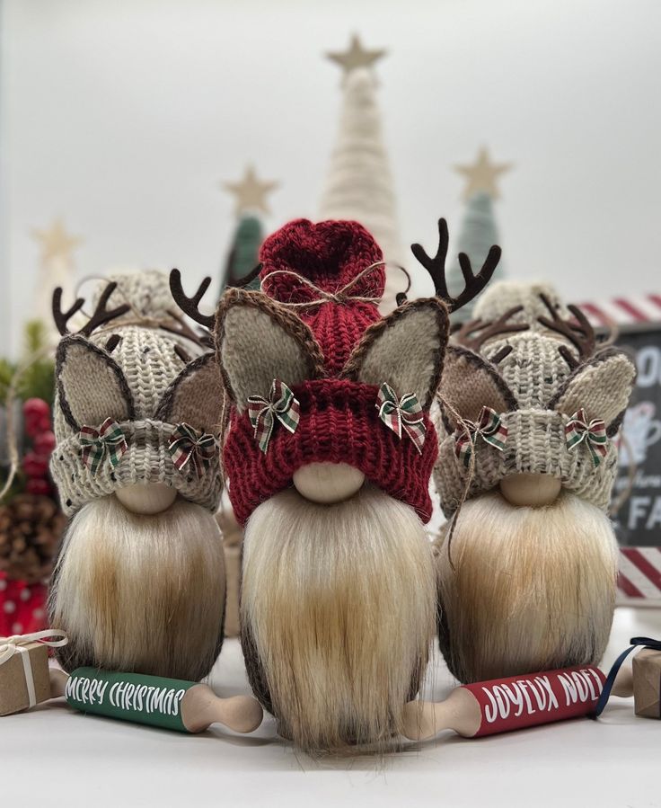 three gnomes wearing knitted hats and reindeer noses