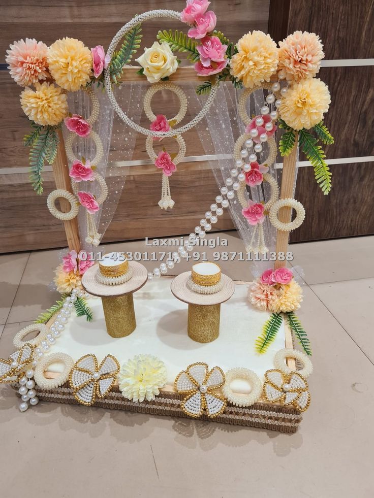 a cake with flowers and pearls on it in front of a wooden backdrop for a wedding ceremony