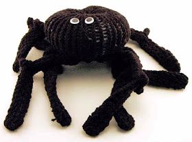 a black knitted spider with eyes and legs