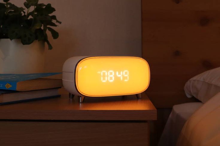 an alarm clock sitting on top of a night stand