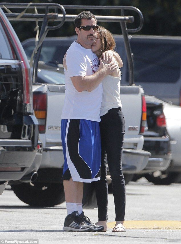 a man and woman hug while standing in the street