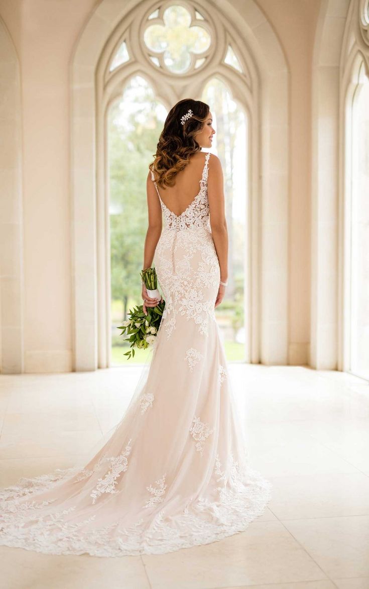 a woman in a wedding dress is standing on the floor with her back to the camera