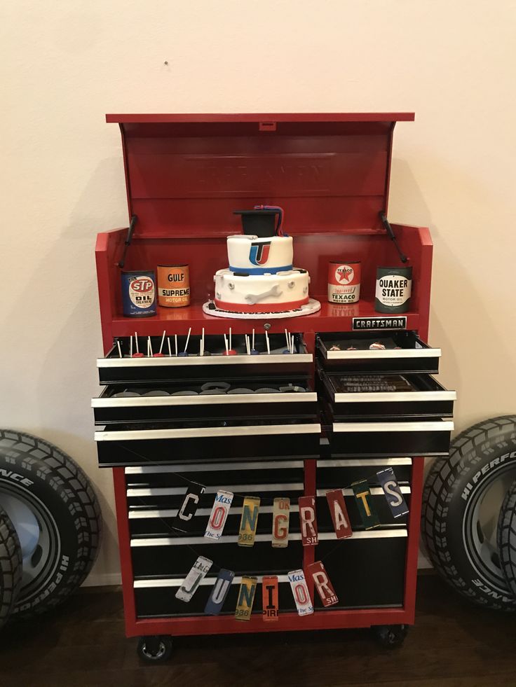 a red toolbox with lots of tools in it and some tires on the ground