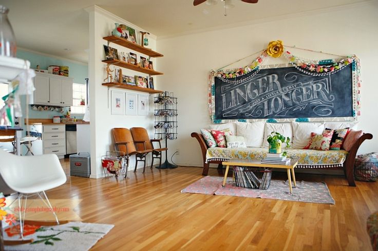 a living room filled with furniture and a chalkboard on the wall