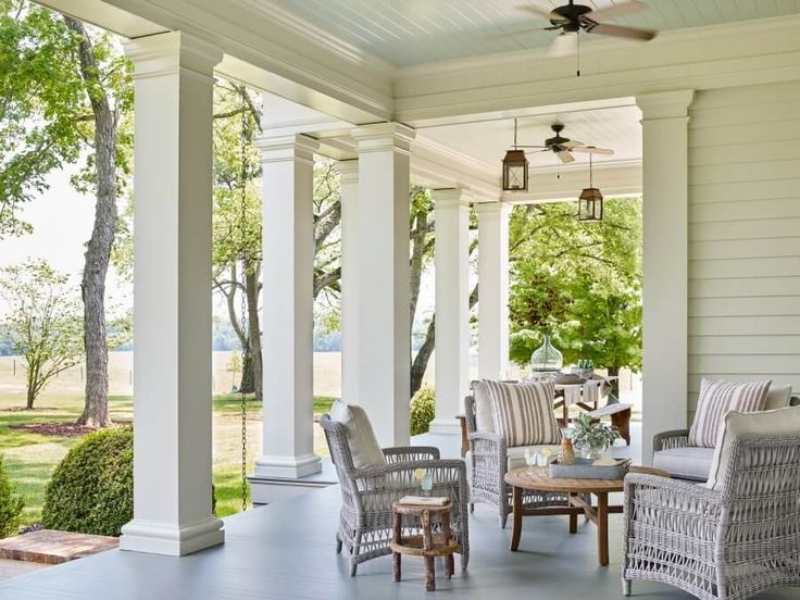 a porch with wicker chairs and tables on it