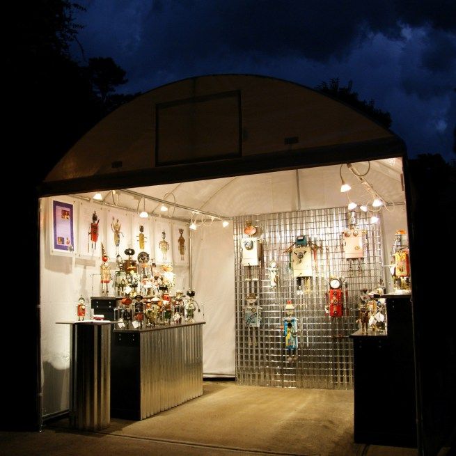 a store front at night with lights on and decorations hanging from the ceiling, all lit up