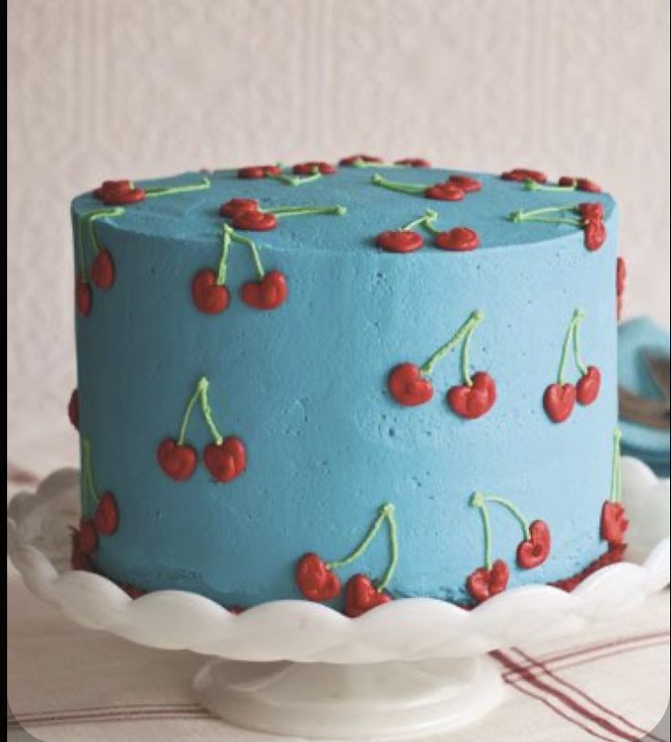 a blue cake with cherries on it