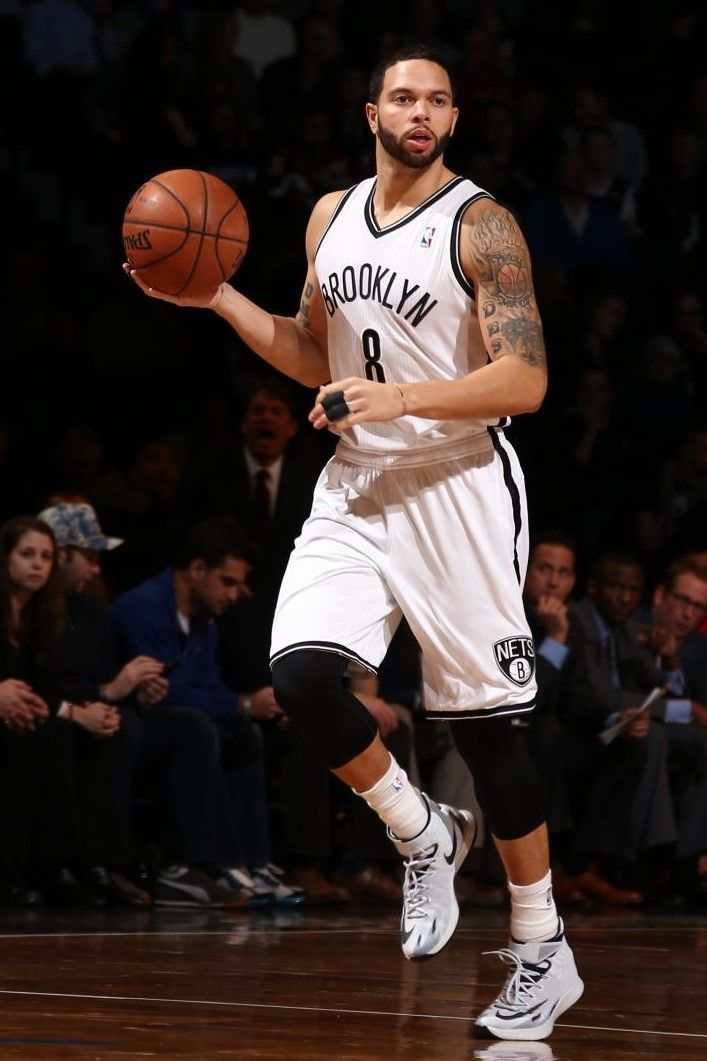 a man with a basketball in his hand and people watching from the stands behind him