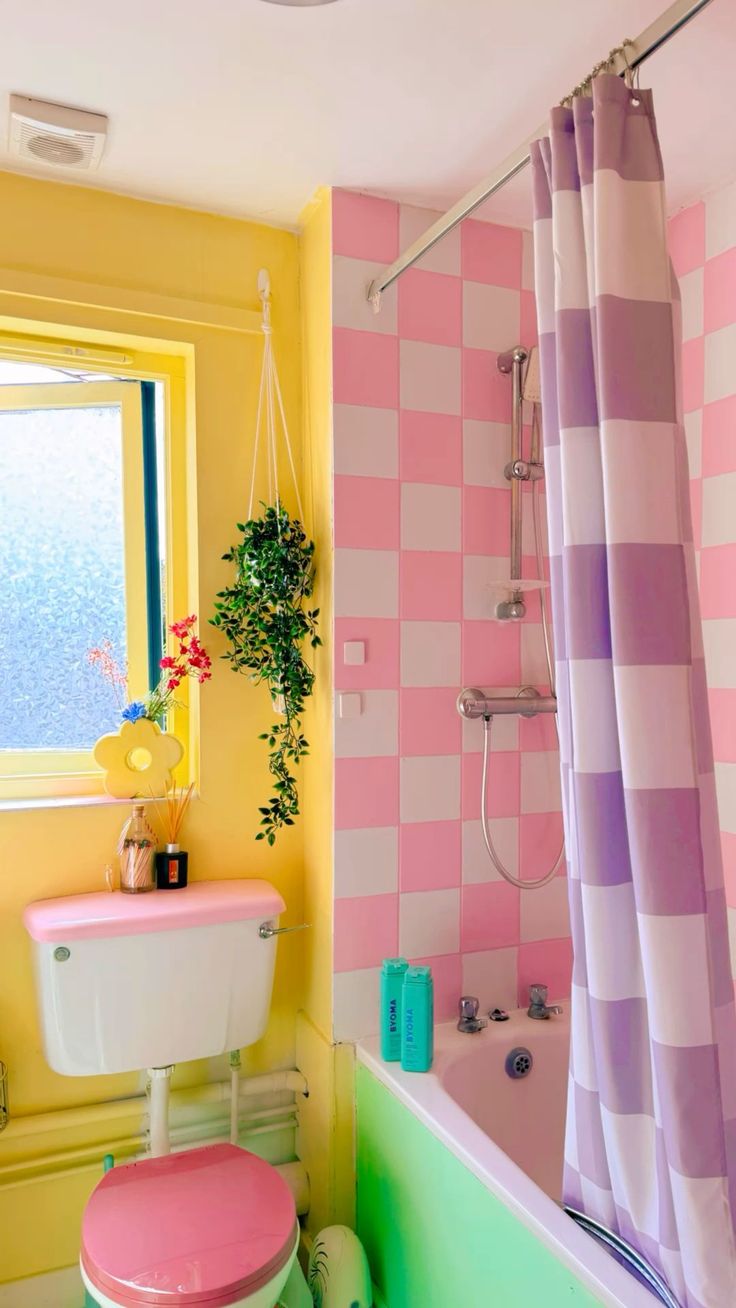 a pink and yellow bathroom with a toilet, tub, sink and shower curtain in it