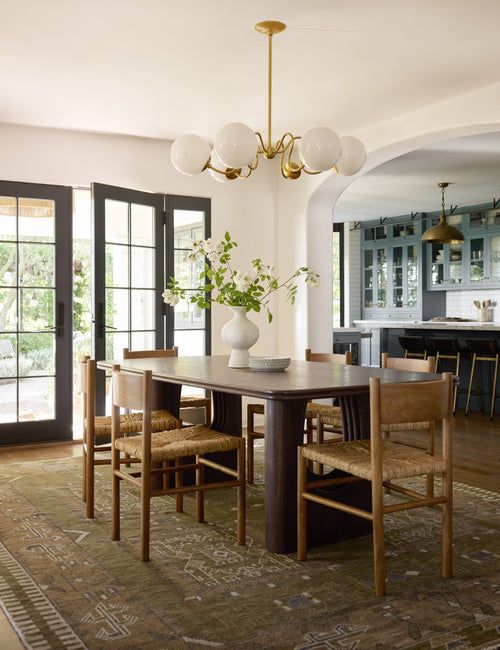 a dining room table with chairs and a potted plant on top of the table