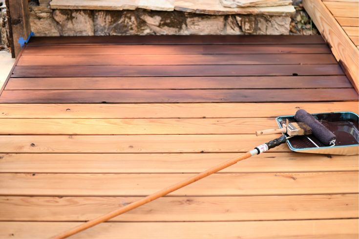 a broom is laying on the wooden deck