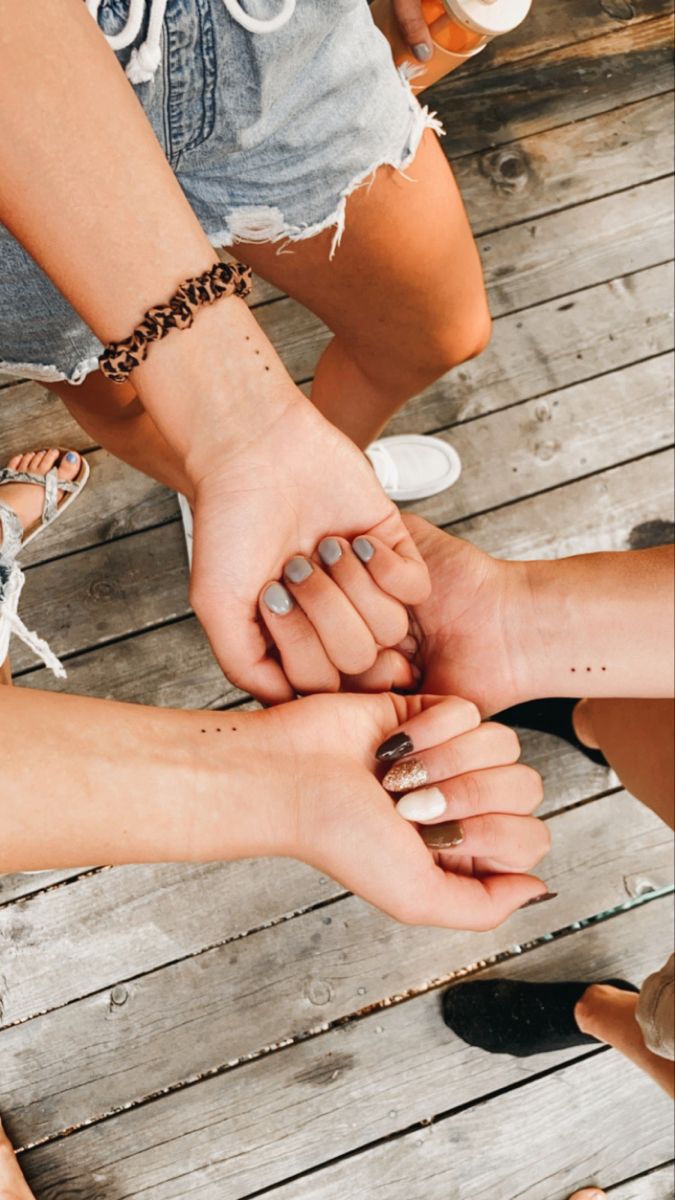 several people holding hands together on a wooden floor