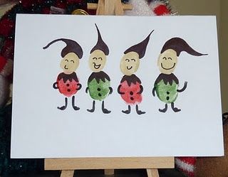 an easel with a painting of three gnomes holding watermelons on it