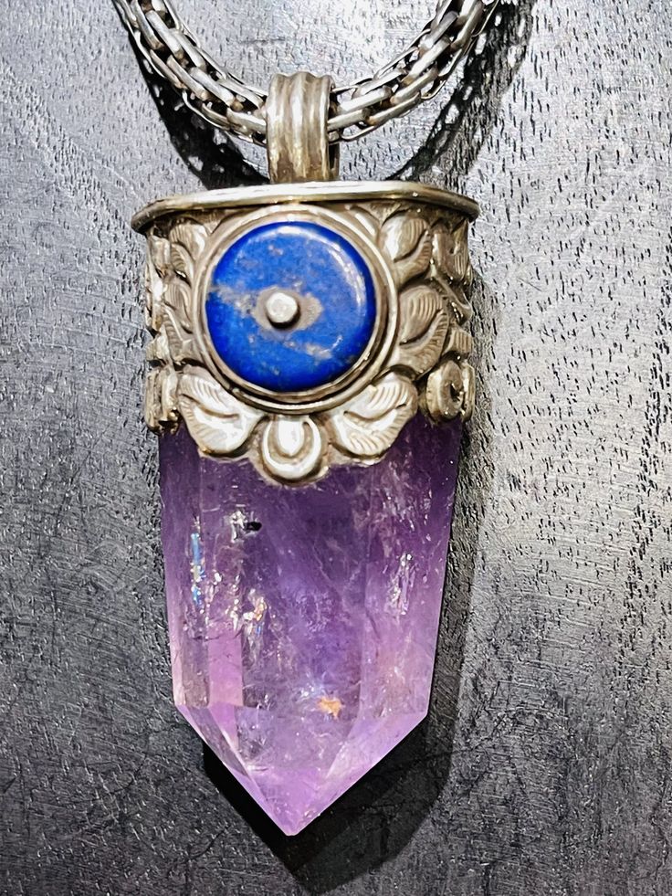 Amazing Amethyst and Lapis Pendant! One of a kind. Made by our friend, Kesang in Nepal. Handmade, fair trade. 2.5”L Spiritual Purple Jewelry With Large Pendant, Spiritual Purple Jewelry For Festivals, Collectible Spiritual Purple Necklace, Handmade Amethyst Crystals For Meditation, Spiritual Amethyst Jewelry For Festivals, Engraved Amethyst Spiritual Jewelry, Spiritual Engraved Amethyst Jewelry, Handmade Amethyst Jewelry For Meditation, Handmade Amethyst Pendant Crystal