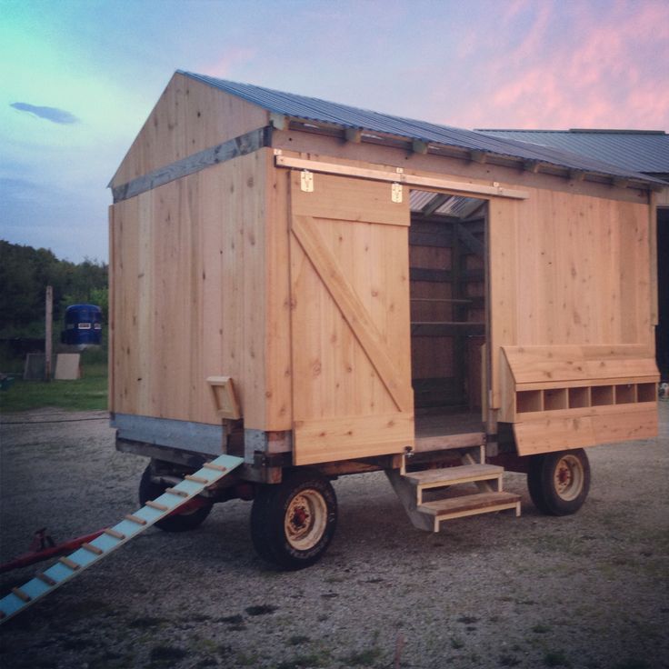 a small wooden building on wheels with a ramp