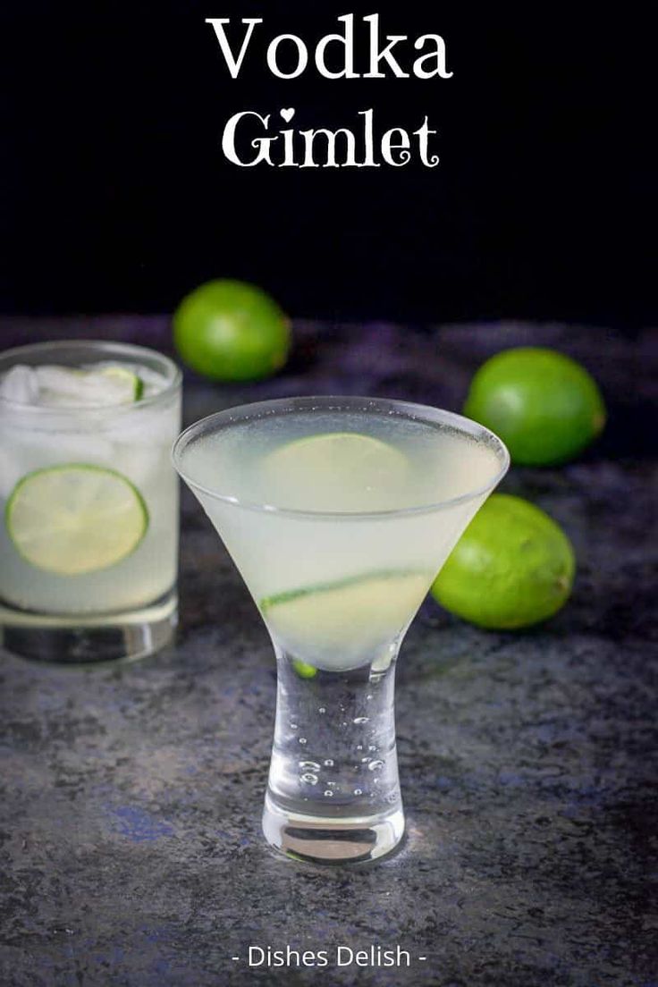 two glasses filled with lemonade and limes on top of a stone countertop