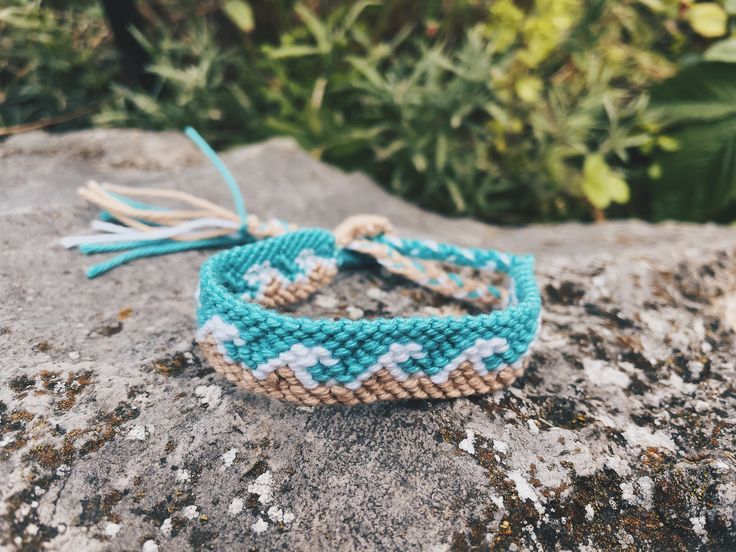 two bracelets sitting on top of a rock