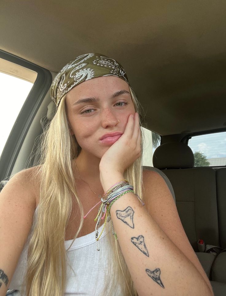 a woman sitting in the back seat of a car with her hand on her face