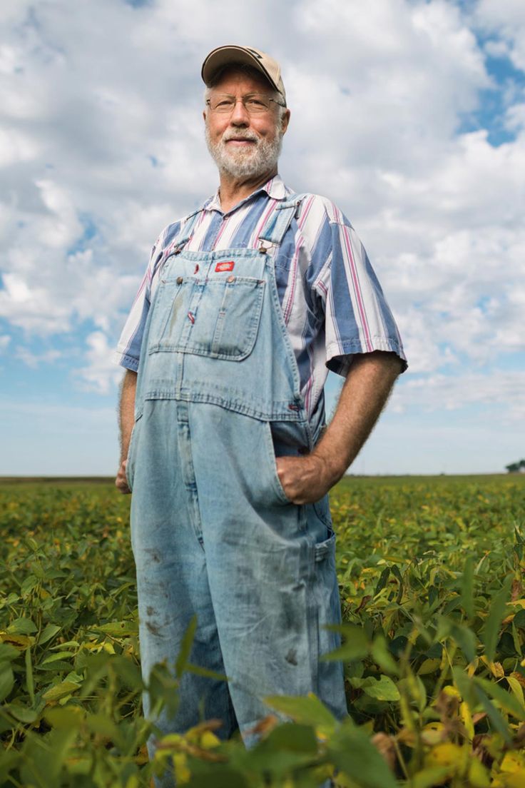 an older man standing in the middle of a field