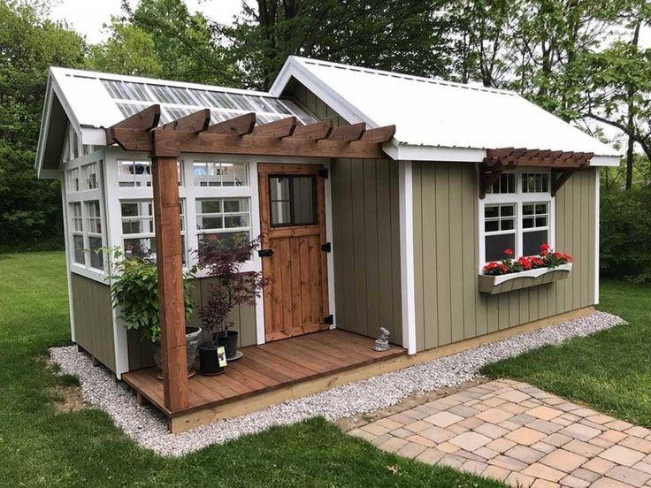 a small shed with windows and plants in it