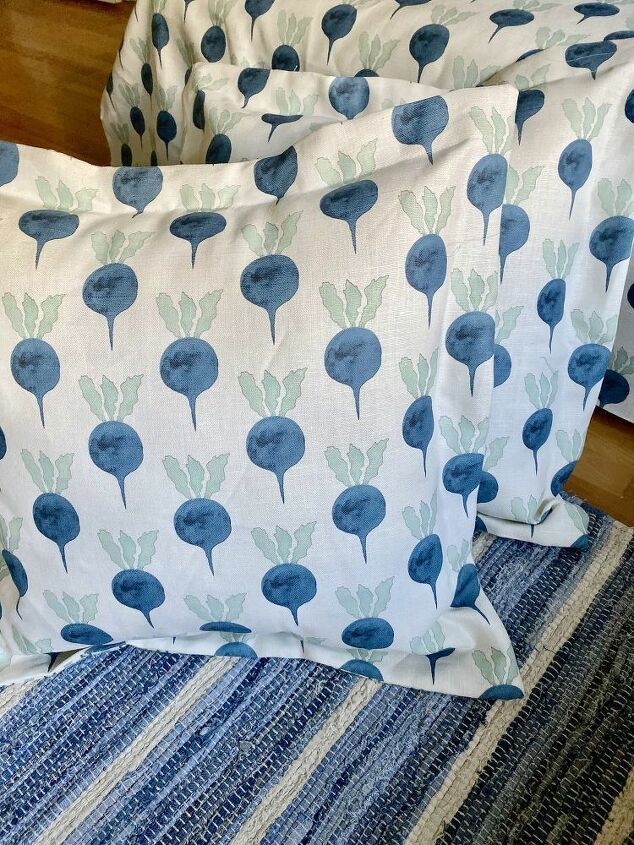 two pillows sitting on top of a bed covered in blue and green flowers next to each other