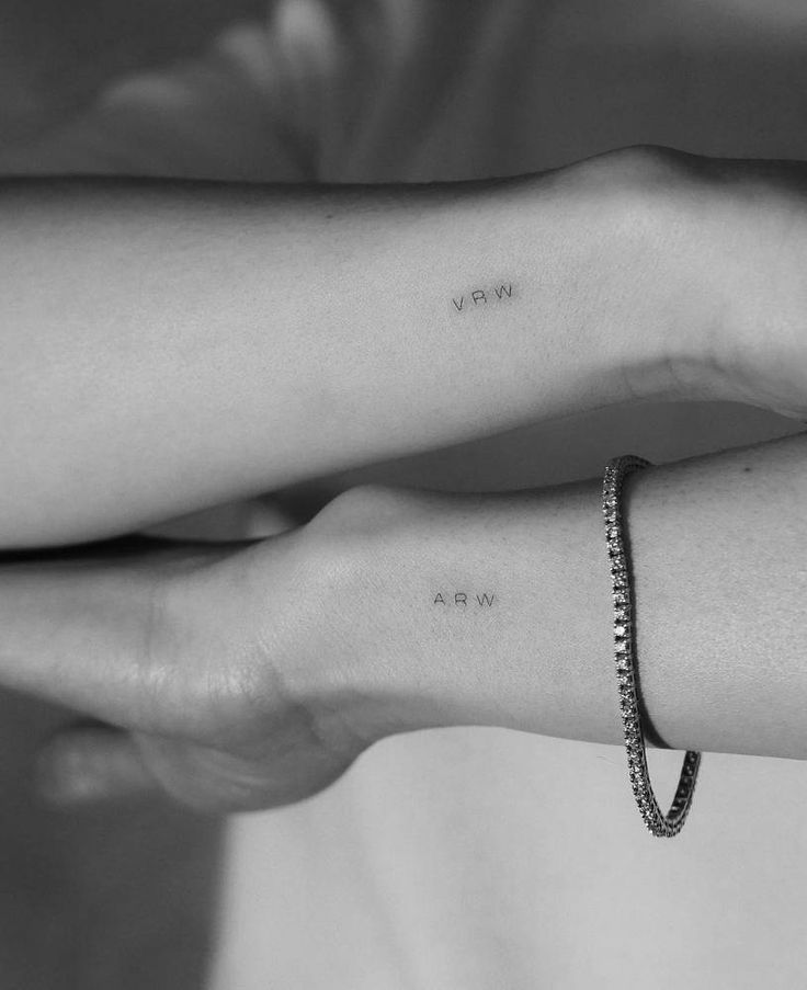 two hands holding each other with the word love on their wrist and one has a diamond bracelet