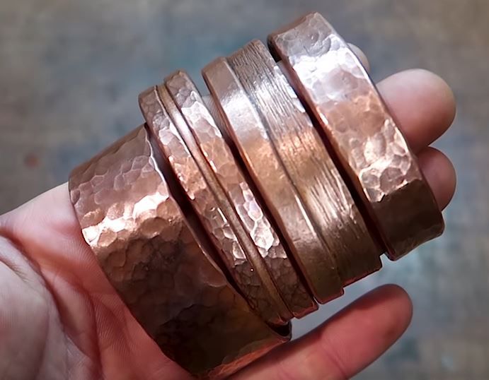 a person is holding some copper rings in their hand and it looks like they are made out of metal