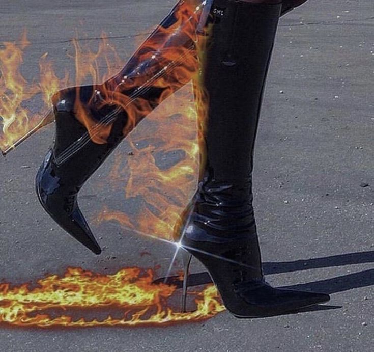 a woman in black boots with flames on the ground