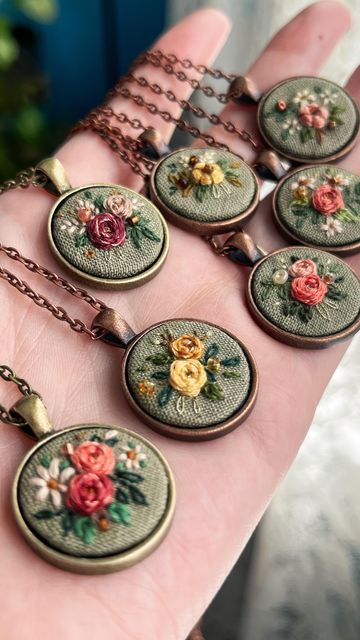 a person is holding nine necklaces with flowers on them