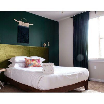 a bedroom with green walls and white bedding