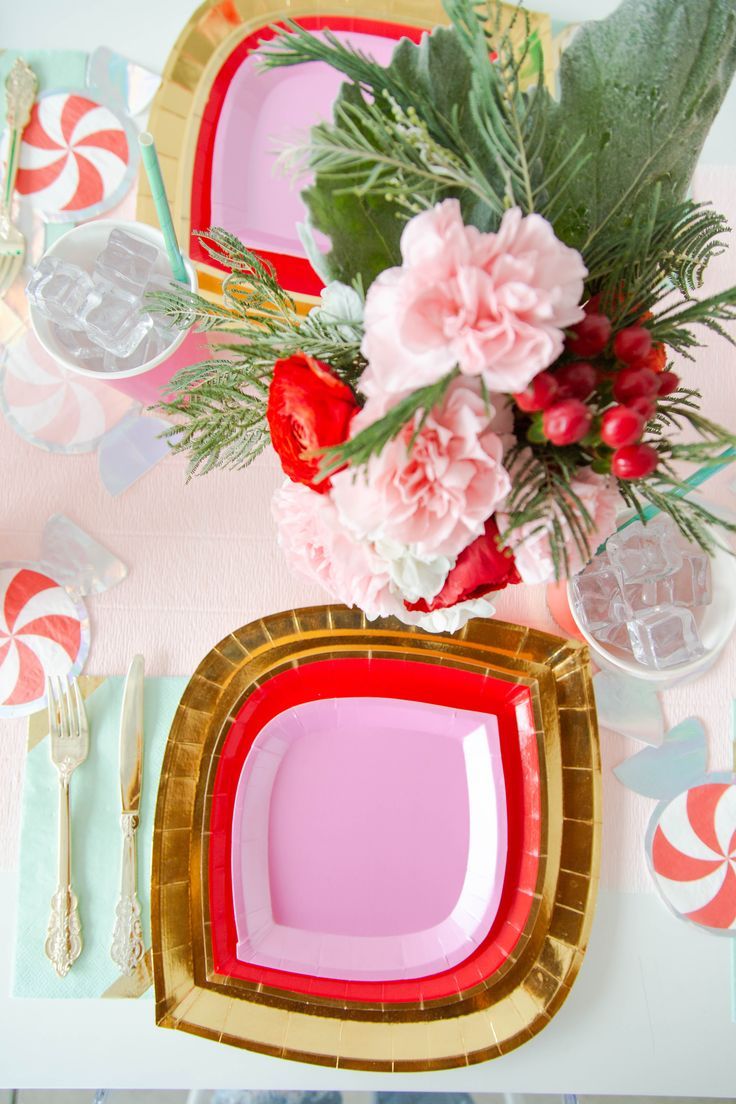 a pink and gold place setting with flowers