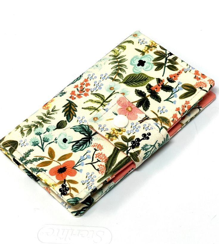 a small wallet with flowers and leaves on it