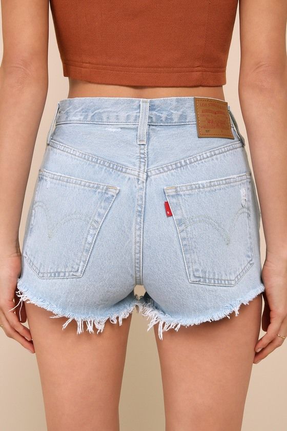 Warm weather is here and it's time to show off those sweet stems in the Levi's 501 Original Light Wash High Rise Cutoff Denim Shorts! Sturdy cotton denim (in Levi's Promise Me wash) shapes these cute shorts with a classic five-pocket cut, belt loops, a branded top button, and a hidden button fly. Subtle whiskering and heavily distressed details lend a lived-in aesthetic! Shredded, cut-off hems complete the look. Red logo tag and leather patch at back. Fit: This garment fits true to size. Length: High Wasted Jean Shorts, Promise Me, Cycling Clothes, 90s Trends, Girl Fashion Style, Fashion Bottoms, Denim Cutoff Shorts, Denim Cutoffs, Levi's 501