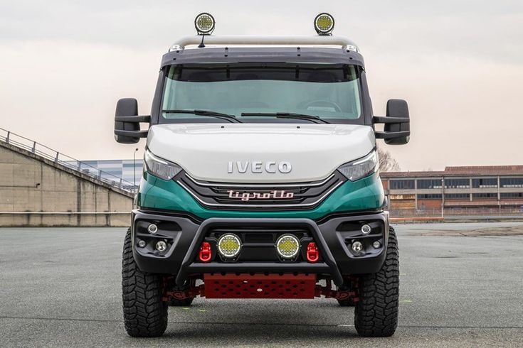 the front end of a white and green truck with lights on it's headlights