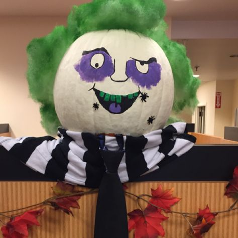 a large pumpkin with a clown's face painted on it in front of a cardboard box