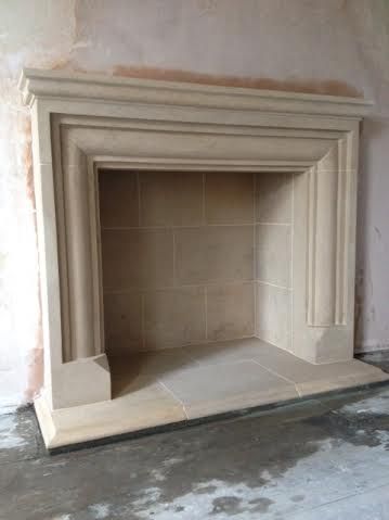 an empty fireplace in the corner of a room