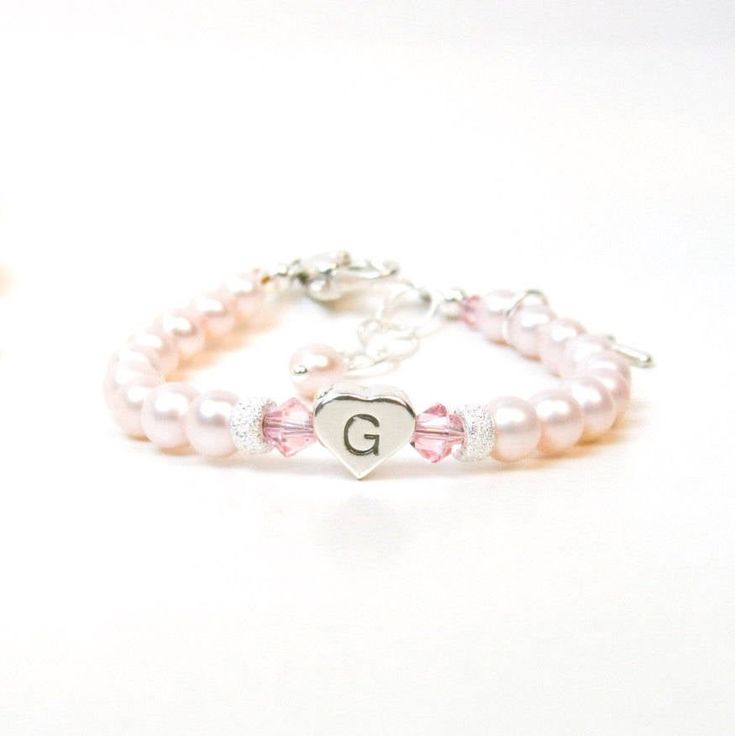 "Personalized Pink Pearl Bracelet for Newborn, Infant, Baby, or Little Girl. This keepsake gift is created with 5mm pink Swarovski crystal pearls, pink Swarovski crystals, a sterling silver heart-shaped initial, 2 sparkling sterling silver stardust spacers, and a heart shaped lobster clasp with a 1/2\" \"Grow-With-Me\" extender chain. You also have your choice of one sterling silver charm, placed near the clasp. ALL metal components are sterling silver. (Star of David charm is silver plated) Arr Adjustable Heart Bracelet With Round Beads For Birthday, Adjustable Beaded Heart Bracelet For Birthday, Elegant Adjustable Rosary Bracelet For Birthday, Adjustable Heart Bracelet For Wedding And Mother's Day, Elegant Adjustable Heart Bracelet For Birthday, Pink Heart Charm Bracelet For Anniversary, Personalized Pink Round Bracelet, Pink Round Rosary Bracelet Gift, Personalized Pink Pearl Bracelet For Birthday